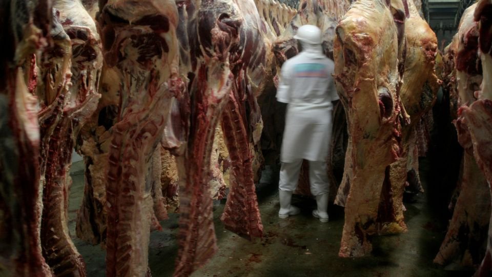 Egy vágóhíd belső területe, ahol húsdarabok lógnak a mennyezetről.