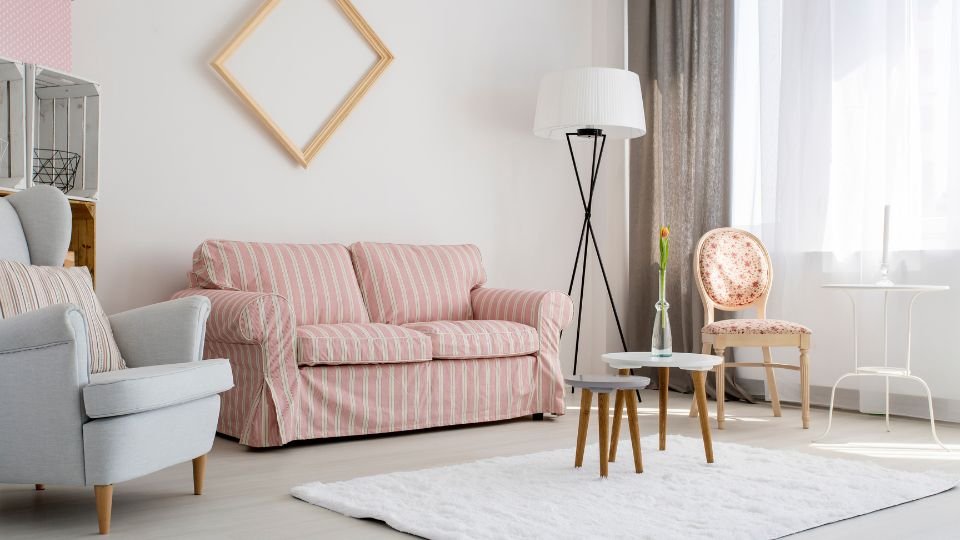 Egy világos, modern nappali, piros csíkos kanapéval és elegáns bútorokkal.