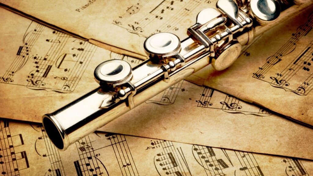 Egy ezüst furulya fekszik régi kottákon, harmonikus látványt teremtve.