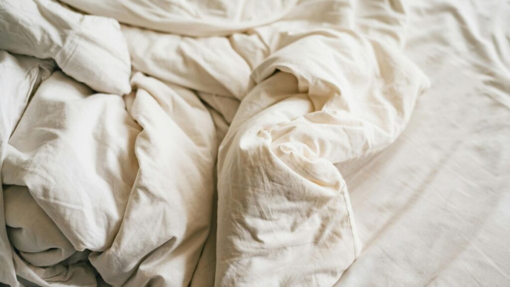 Ágynemű álom jelentése Gyűrött, világos ágynemű egy ágyon, a pihenés és kényelem szimbóluma.