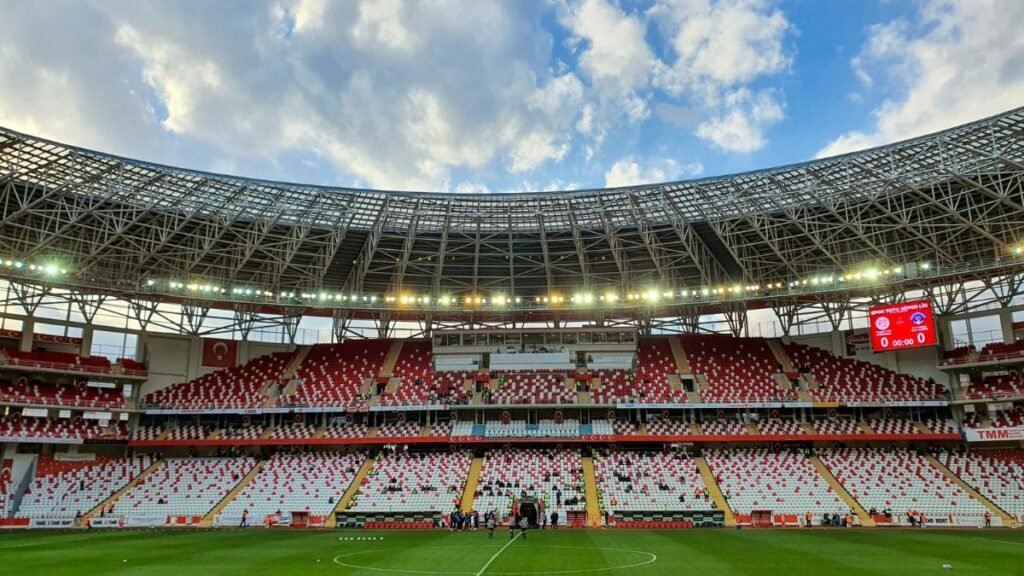 Üres aréna belső nézete, világítással és felhős égbolttal.