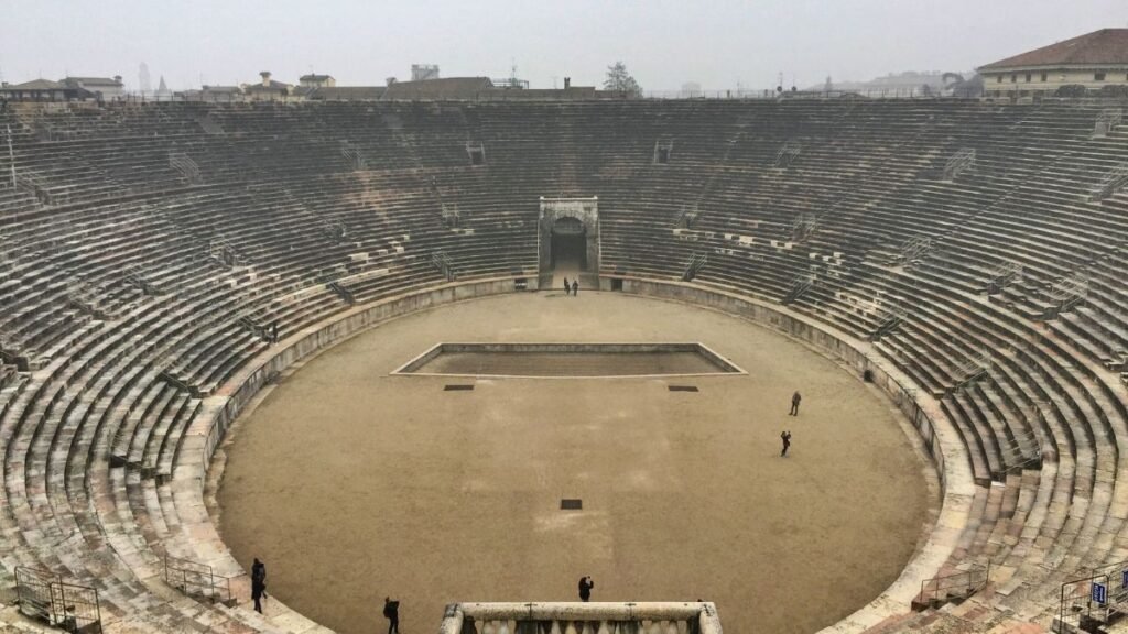 Üres aréna belső tere, ahol az emberek találkoznak és küzdenek.