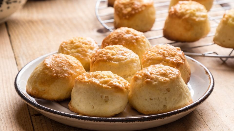 Frissen sült pogácsák egy fehér tányéron, otthonos hangulatot árasztva.