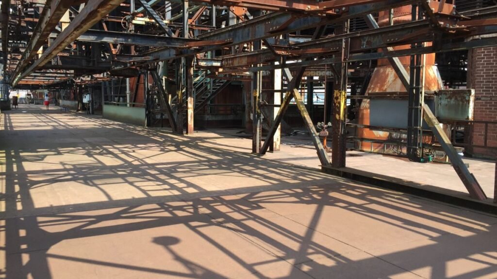 Üres ipari tér, vas szerkezetekkel és árnyékokkal, álomfejtéshez kapcsolódóan.