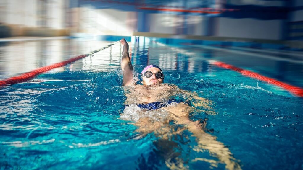 Egy úszó hátúszás közben, a vízben lebegve, nyugodt környezetben.