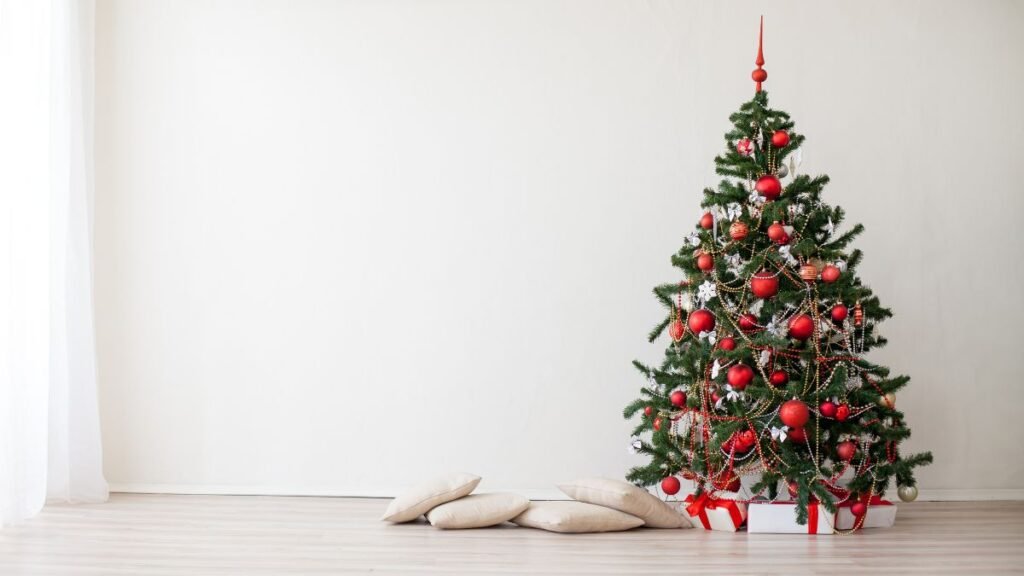 Karácsonyfa az álomban jelentés és értelmezés Díszes karácsonyfa piros és arany díszekkel, fehér fal előtt.