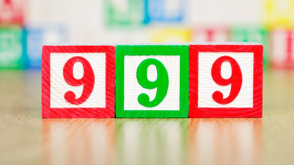 999 álomban mit jelent? Három színes építőkocka, mindegyiken a 999 szám látható, háttérben más kockák.