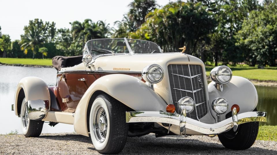 Egy vintage veterán autó, amely a múlt értékeit idézi fel, zöld környezetben.