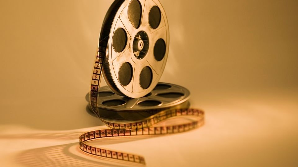 Egy filmtekercs és egy filmes orsó, amely az emlékek és kreativitás szimbóluma.