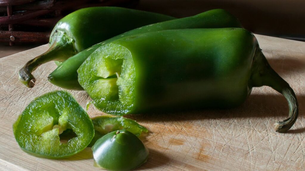 Friss jalapeno paprikák, vágott darabokkal, fűszeres ízeket sugallva.